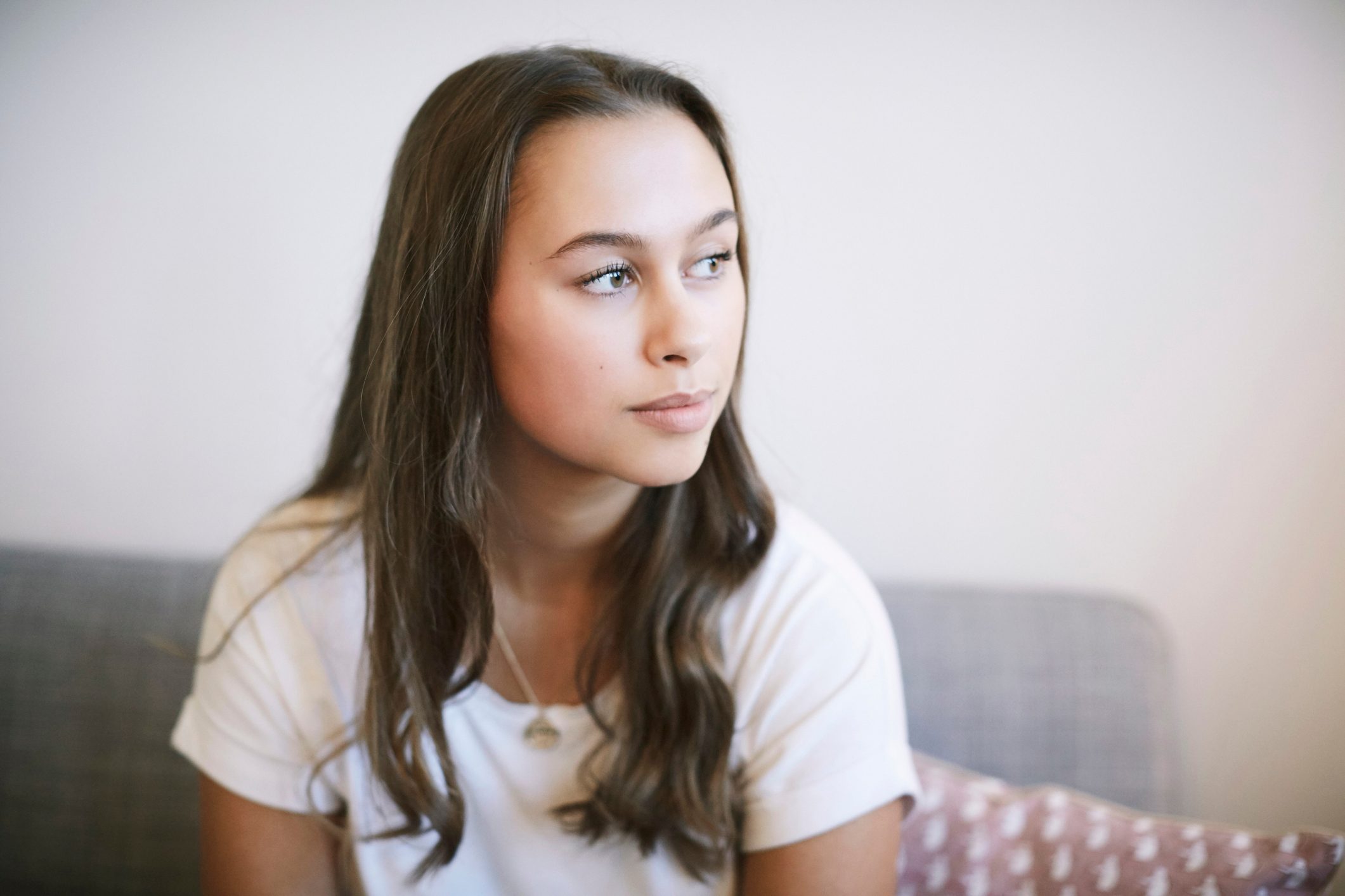 young woman looking out the window thinking