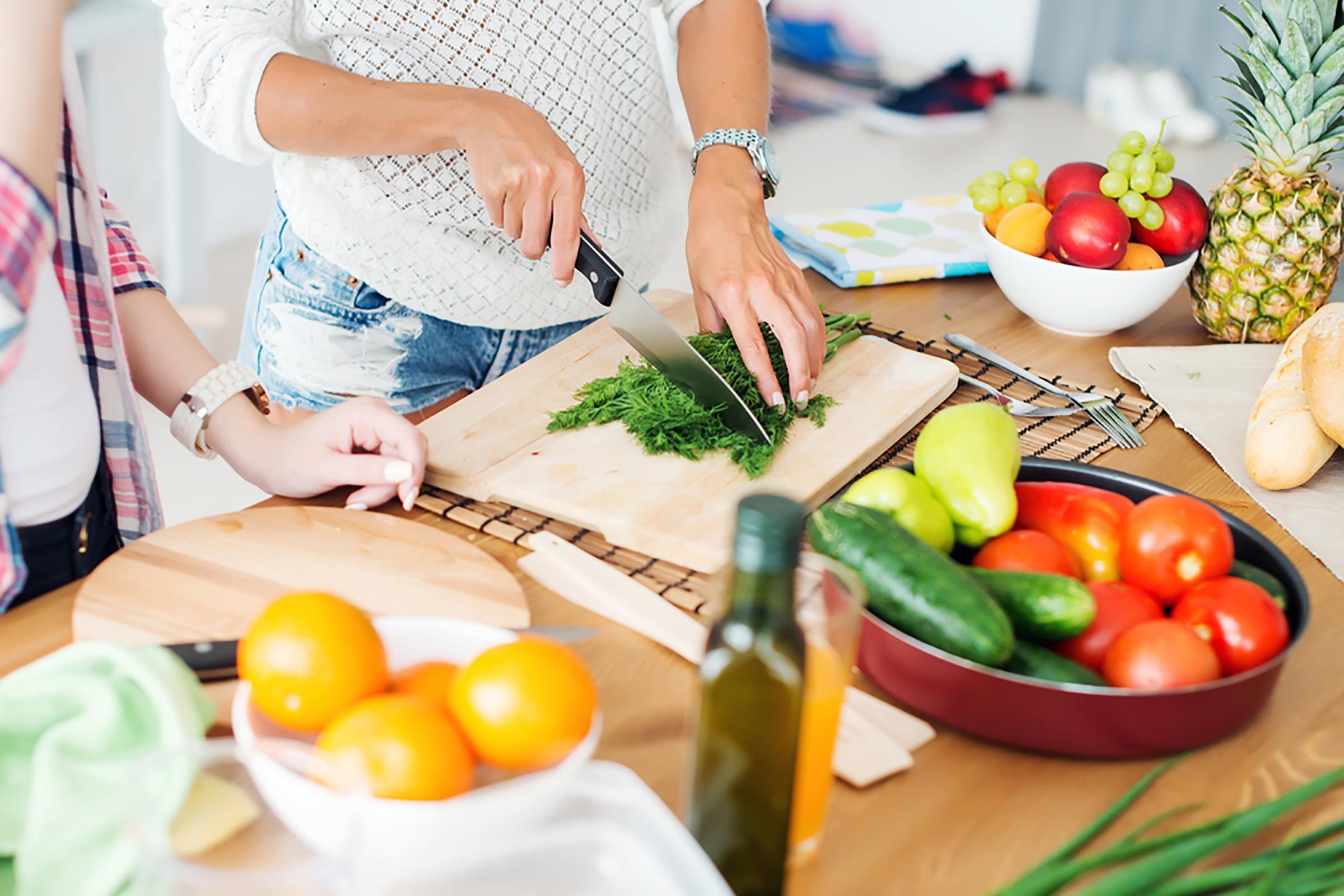 woman chopping herbs on a cutting board