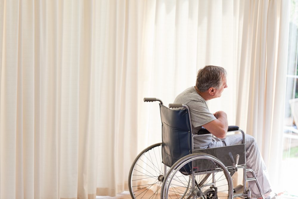 Man in his wheelchair looking out the window