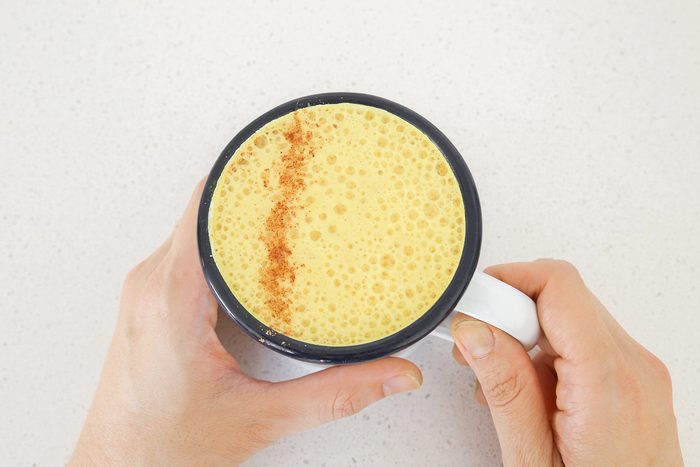 hands holding a cup of golden milk