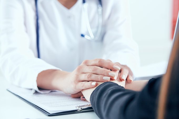 Friendly Female Doctor's Hands Holding Female Patient's Hand For Encouragement And Empathy Close Up. Partnership, Trust And Medical Ethics Concept