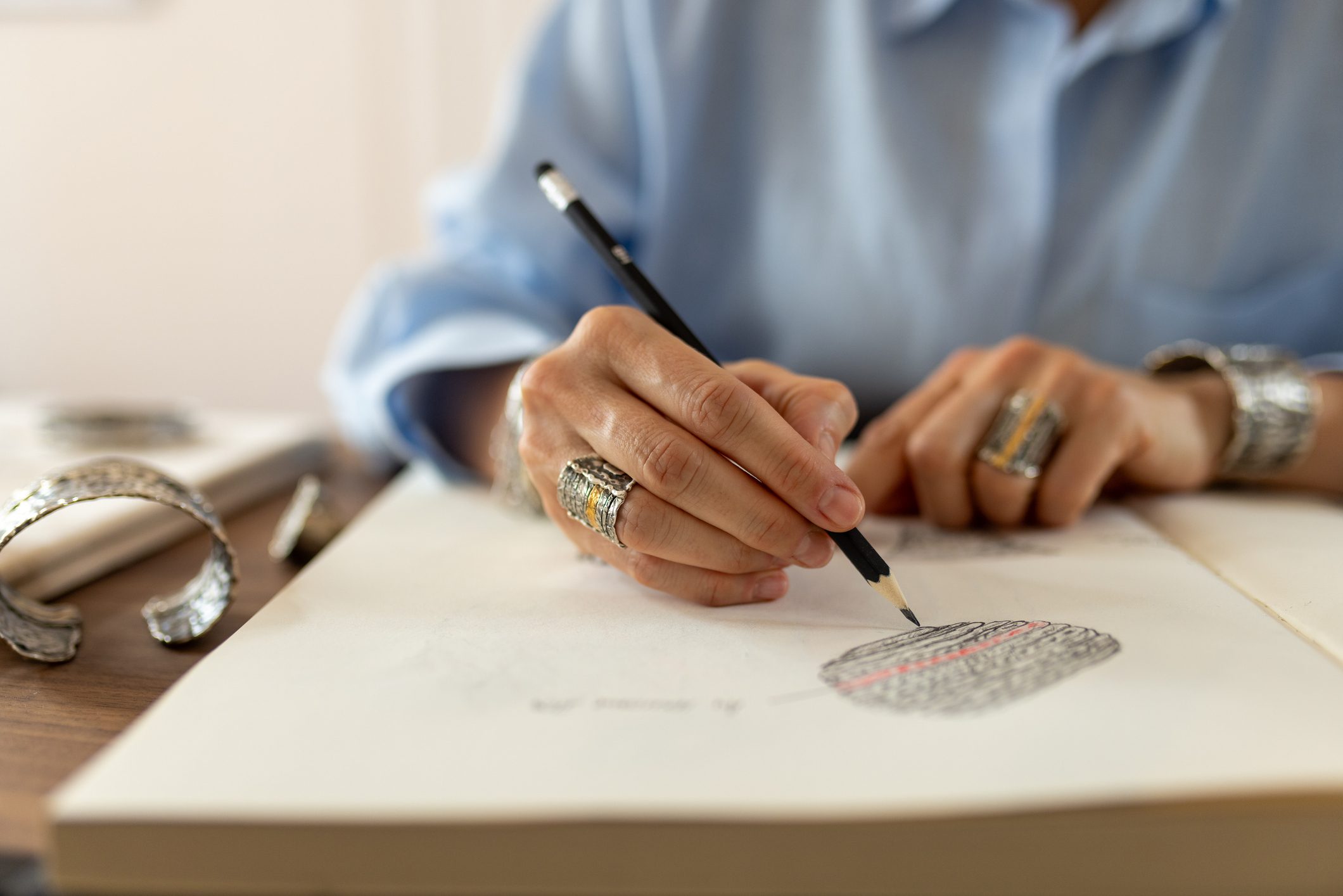 Woman drawing sketches for jewelry in her studio